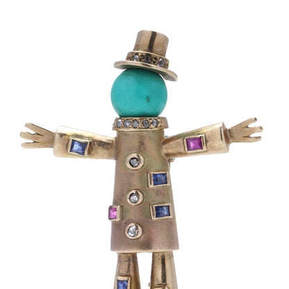 Vintage gold scarecrow brooch with gemstones.