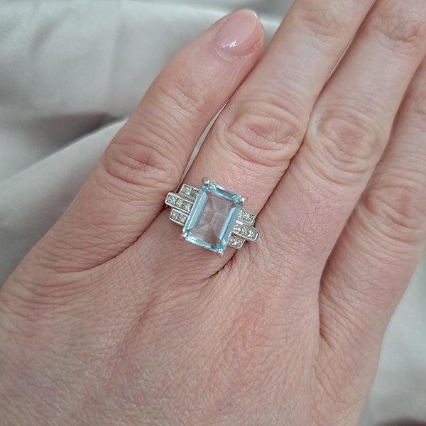 An aquamarine and diamond ring in white metal, modelled on a ring finger