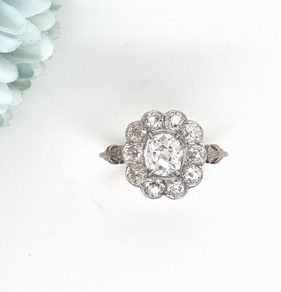 Vintage 1 carat old cut diamond cluster ring with cushion shape old mine cut 0.90 carat diamond in the centre surrounded by 10 diamonds totaling 1.15 carats set in platinum.