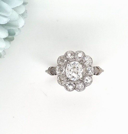 Vintage 1 carat old cut diamond cluster ring with cushion shape old mine cut 0.90 carat diamond in the centre surrounded by 10 diamonds totaling 1.15 carats set in platinum.