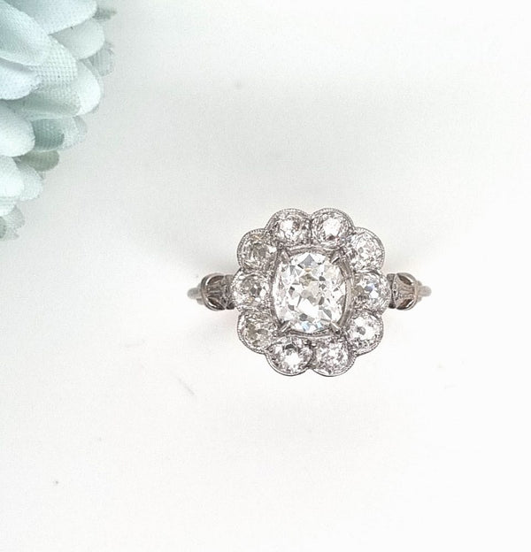 Vintage 1 carat old cut diamond cluster ring with cushion shape old mine cut 0.90 carat diamond in the centre surrounded by 10 diamonds totaling 1.15 carats set in platinum.