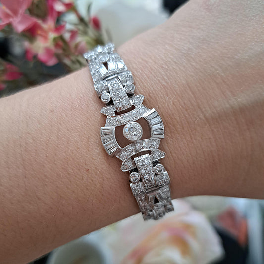 Art Deco Diamond Bracelet in Platinum, set with a geometric design of old-cut and baguette-cut diamonds. Secured with a decorative hidden clasp