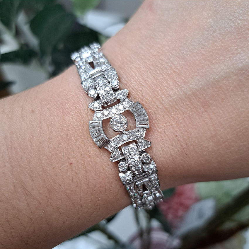 Art Deco Diamond Bracelet in Platinum, set with a geometric design of old-cut and baguette-cut diamonds. Secured with a decorative hidden clasp