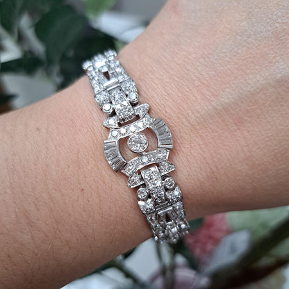 Art Deco Diamond Bracelet in Platinum, set with a geometric design of old-cut and baguette-cut diamonds. Secured with a decorative hidden clasp