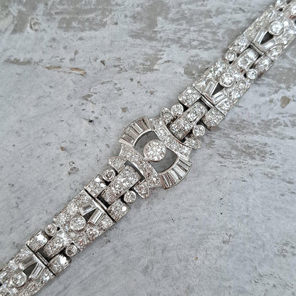 Art Deco Diamond Bracelet in Platinum, set with a geometric design of old-cut and baguette-cut diamonds. Secured with a decorative hidden clasp