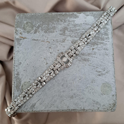 Art Deco Diamond Bracelet in Platinum, set with a geometric design of old-cut and baguette-cut diamonds. Secured with a decorative hidden clasp