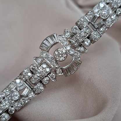 Art Deco Diamond Bracelet in Platinum, set with a geometric design of old-cut and baguette-cut diamonds. Secured with a decorative hidden clasp