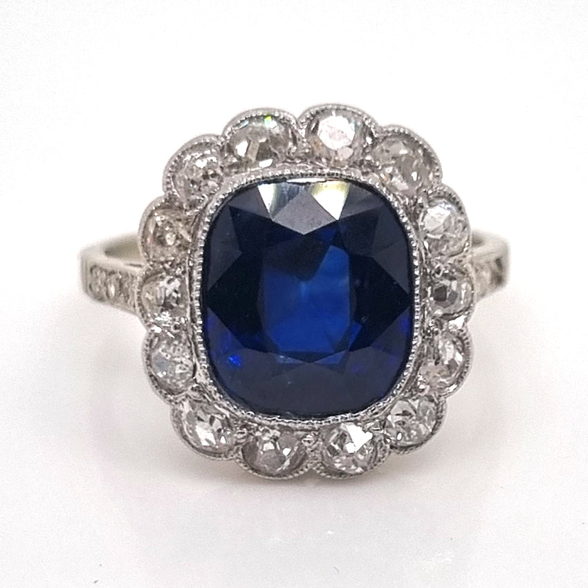 Art Deco 3ct Natural No Heat Sapphire and Diamond Cluster Engagement Ring, 3ct cushion-shaped natural sapphire with no heat treatment surrounded by sparkling diamonds in platinum with millegrain edging