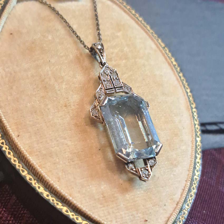 Art Deco Aquamarine and Diamond Pendant, 10.47ct emerald-shaped step-cut aquamarine accented with diamond-set geometric top and bottom in 14ct white gold