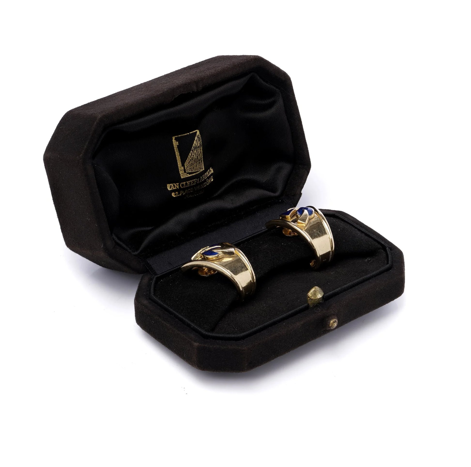 A pair of yellow gold earrings with blue enamel leaves and round diamonds, in a black box, on a white background