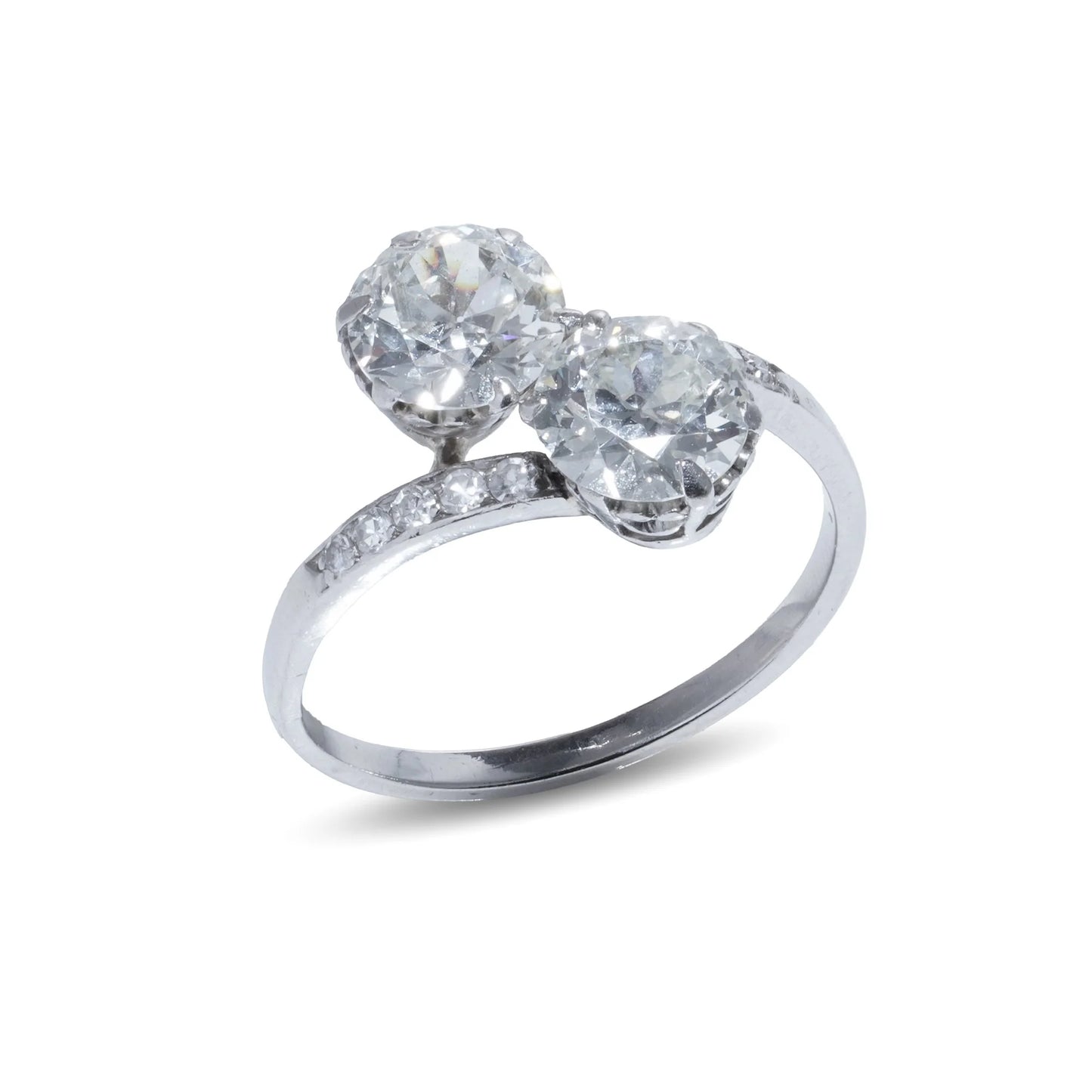 A two stone diamond crossover ring in white gold with diamond shoulders, on a white background