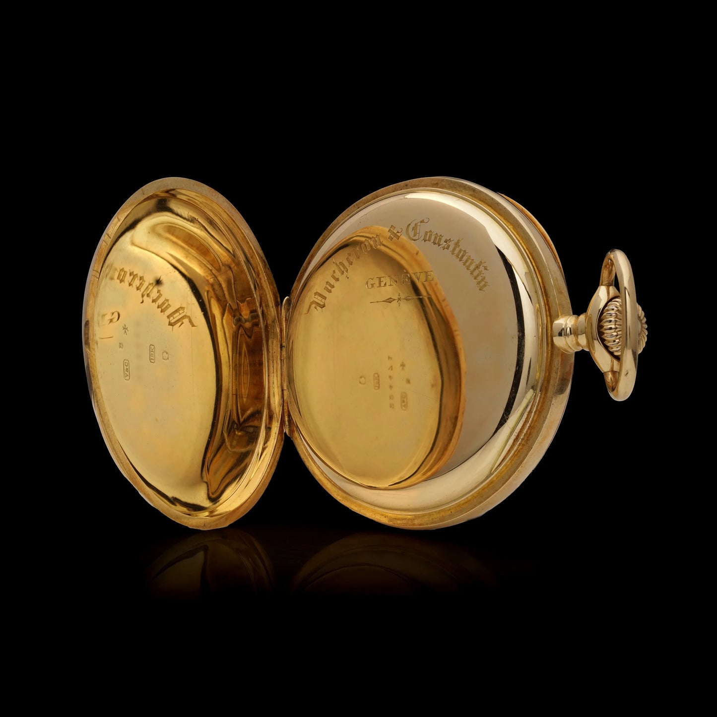 A yellow gold pocket watch with the back case open, engraved Vacheron & Constantin, on a black background