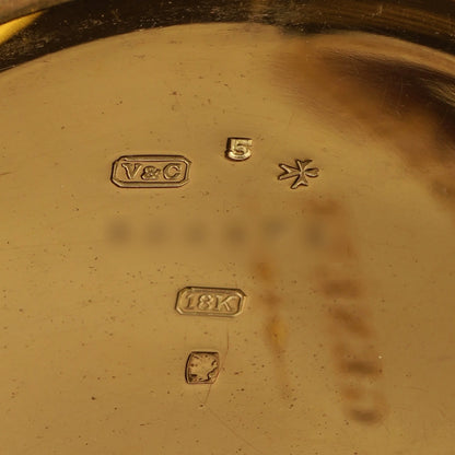 Close-up of stamps inside a yellow gold case, stamped 18K V&C