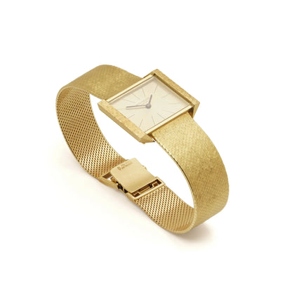 A yellow gold Patek Phillipe wristwatch with integrated bracelet, on a white background