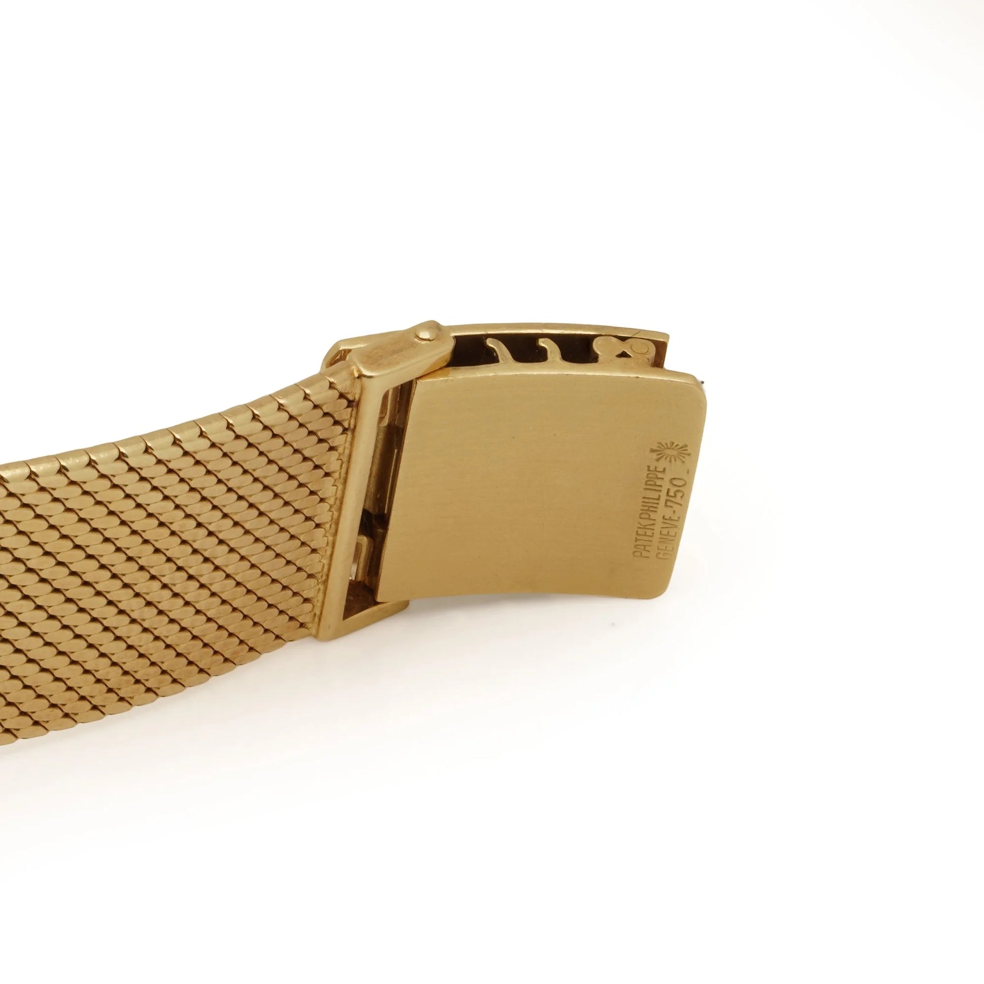 Close-up on a yellow gold watch bracelet clasp stamped PATEK PHILLIPE GENEVE 750