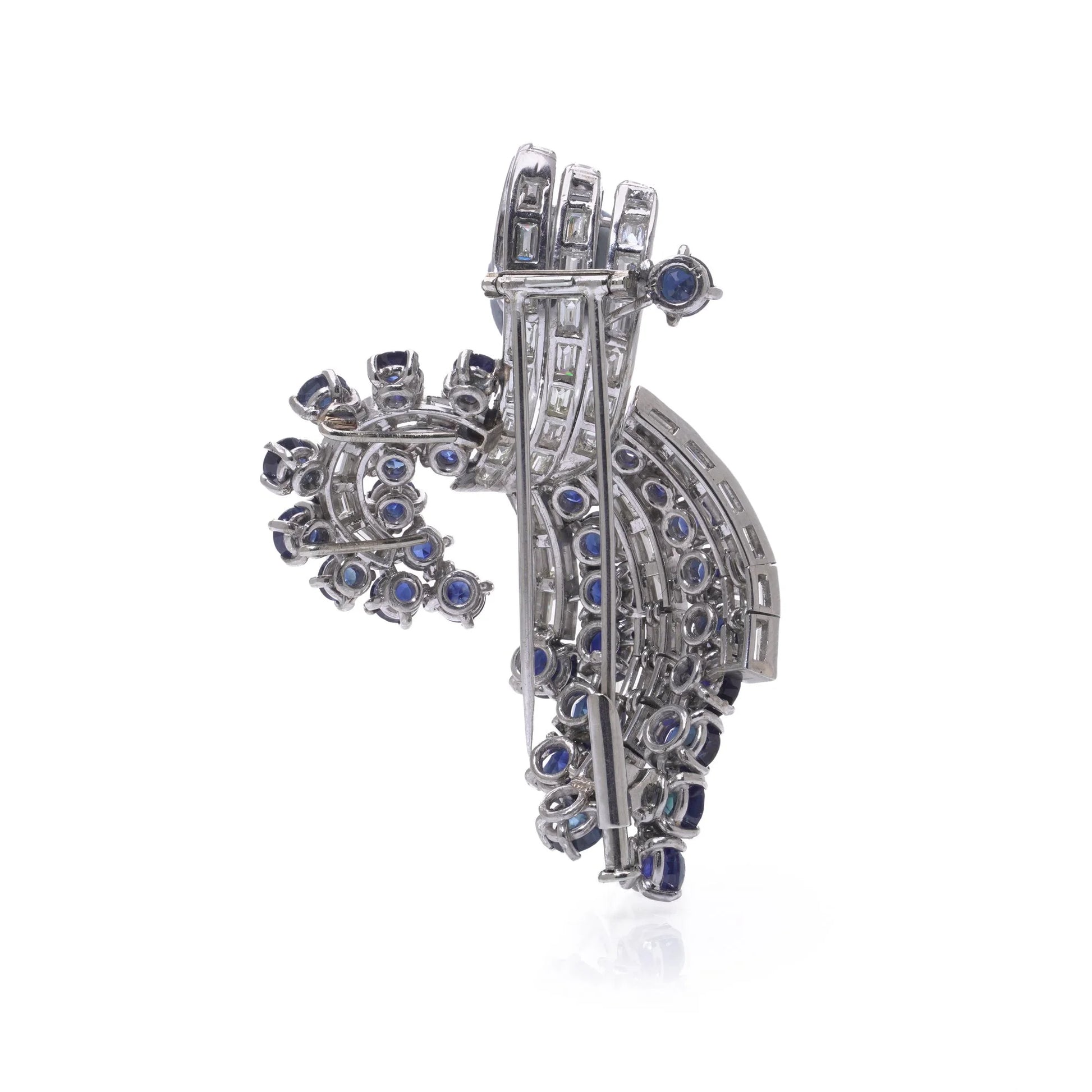 A decorative baguette cut diamond and round sapphire brooch in white metal, on a white background