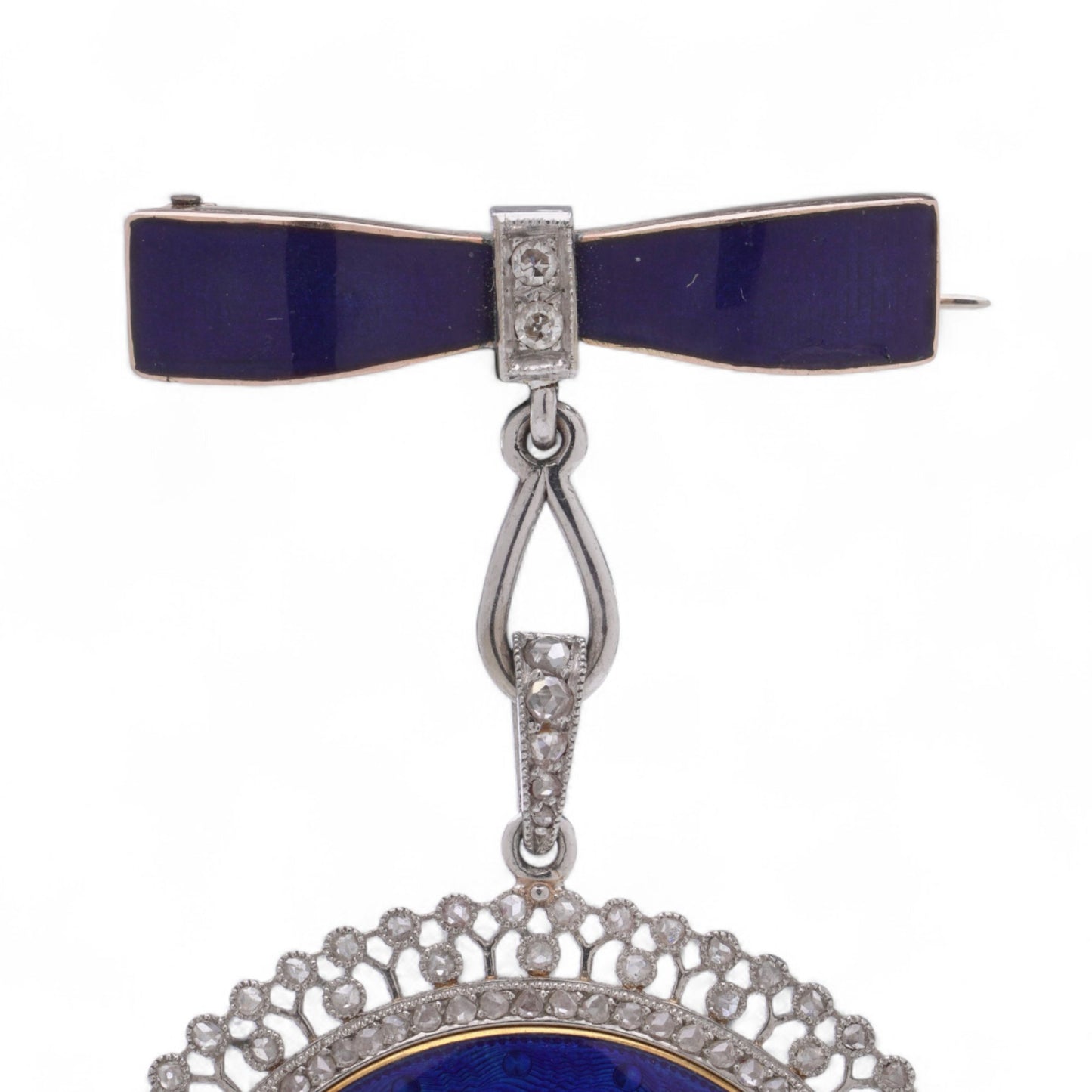 A blue enamel pendant pocket watch in silver with diamonds, suspended by a bow brooch fitting, on a white background