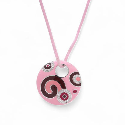 A pink enamel circular pendant with diamonds on a pink cord, on a white background