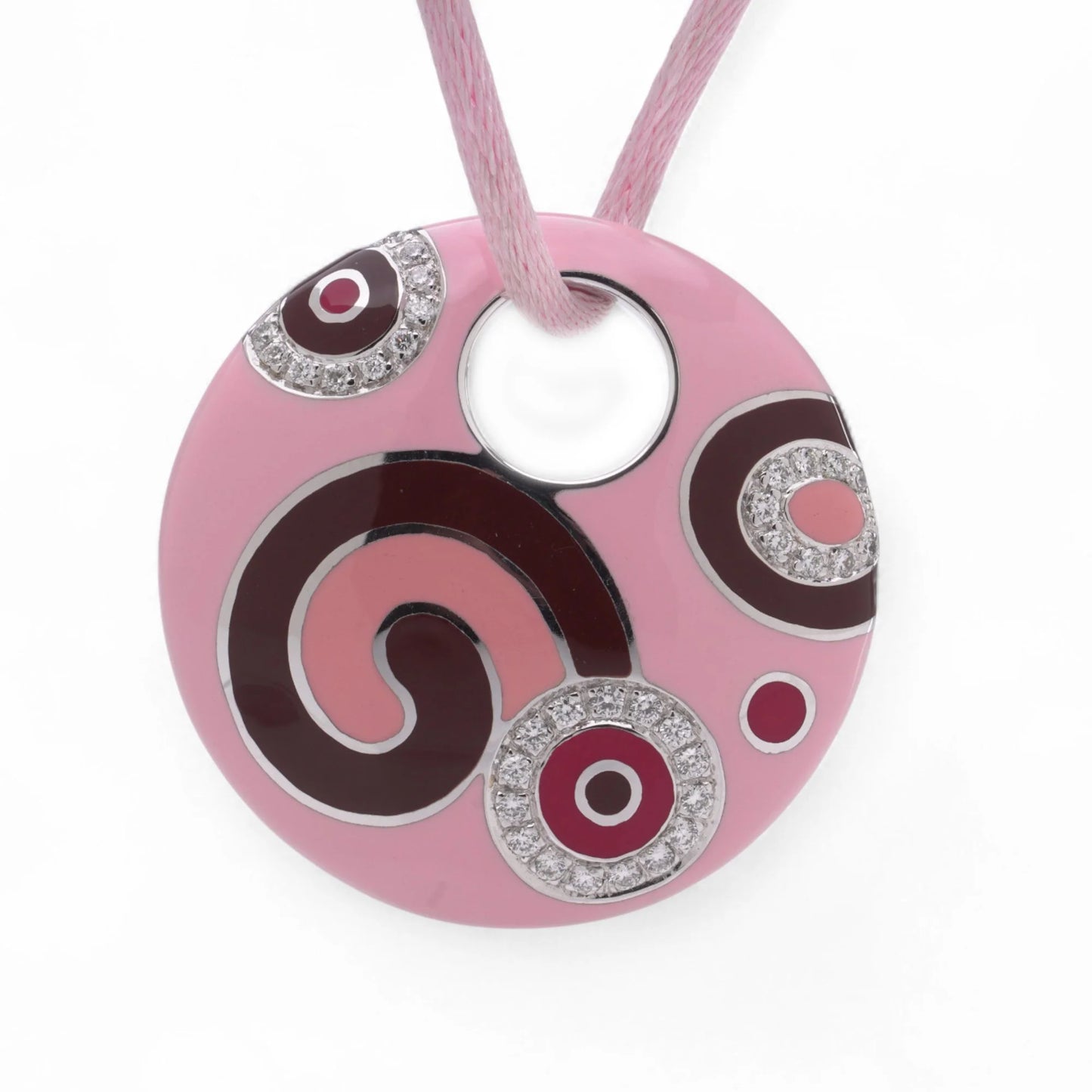 A pink enamel circular pendant with diamonds on a pink cord, on a white background