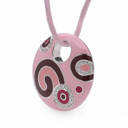 A pink enamel circular pendant with diamonds on a pink cord, on a white background
