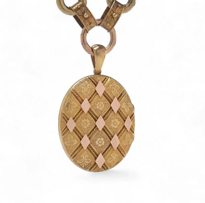 An antique yellow and rose gold fancy link necklace with an oval locket pendant, on a white background