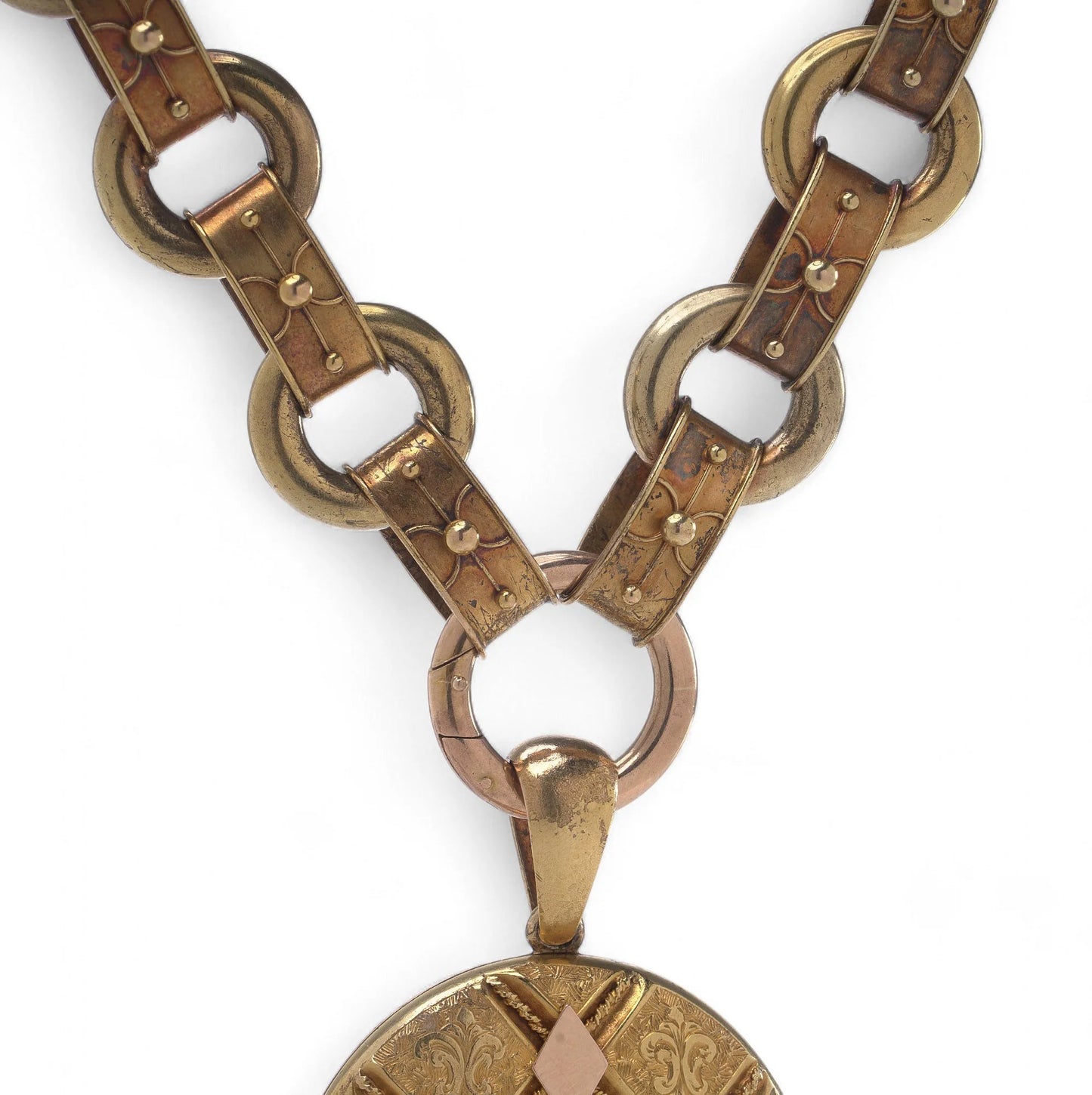 An antique yellow and rose gold fancy link necklace with an oval locket pendant, on a white background