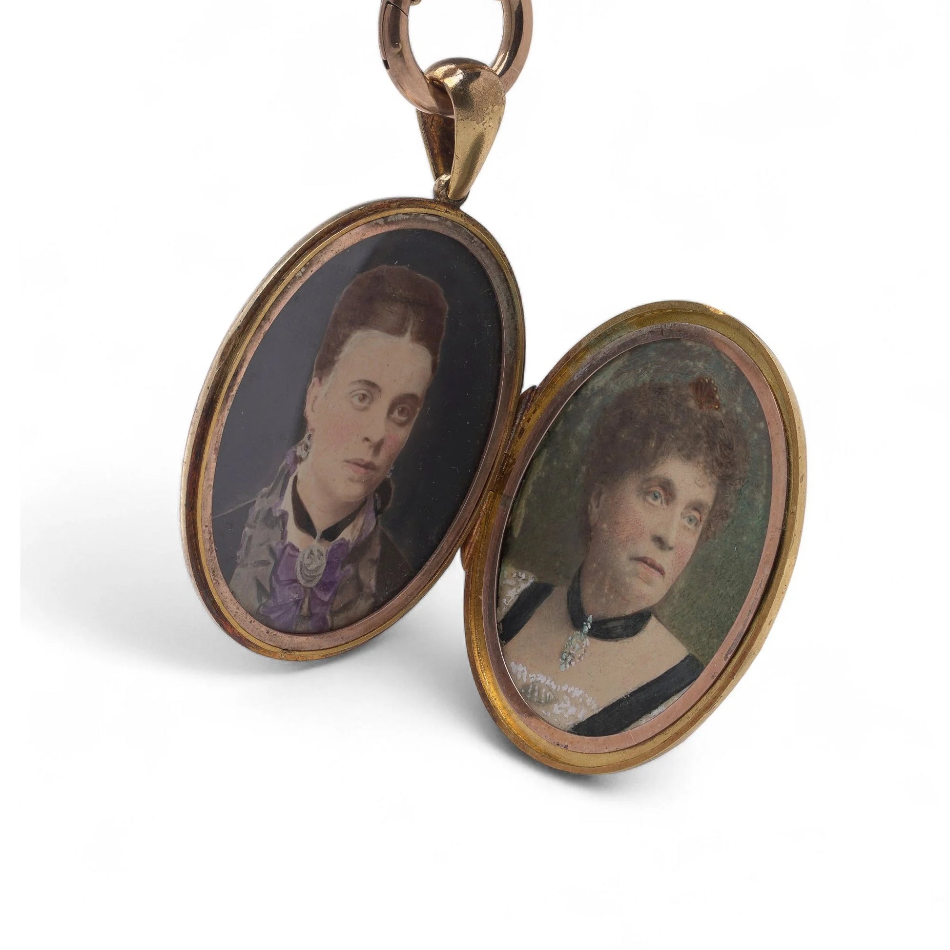 An open gold locket displaying wo female Victorian coloured portraits, on a white background