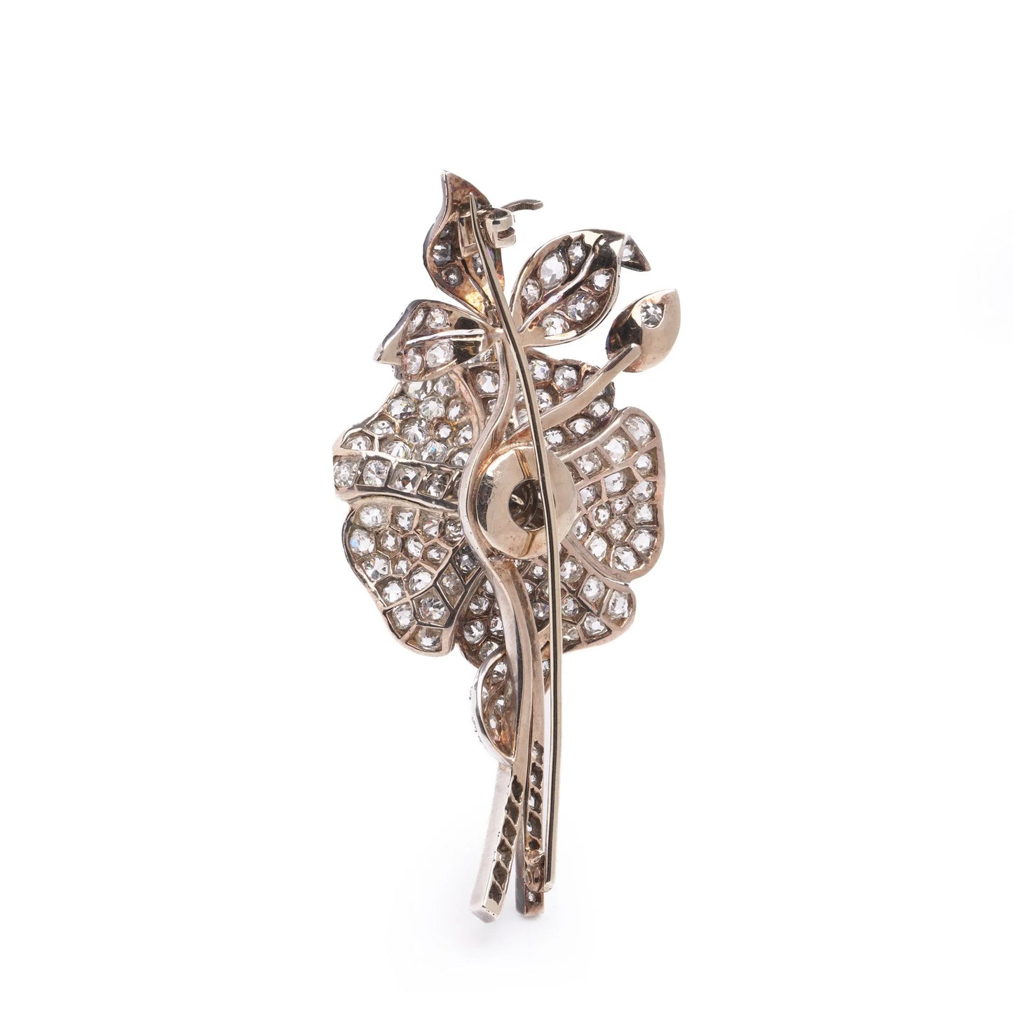 A decorative flower brooch set with diamonds, in silver and gold, on a white background