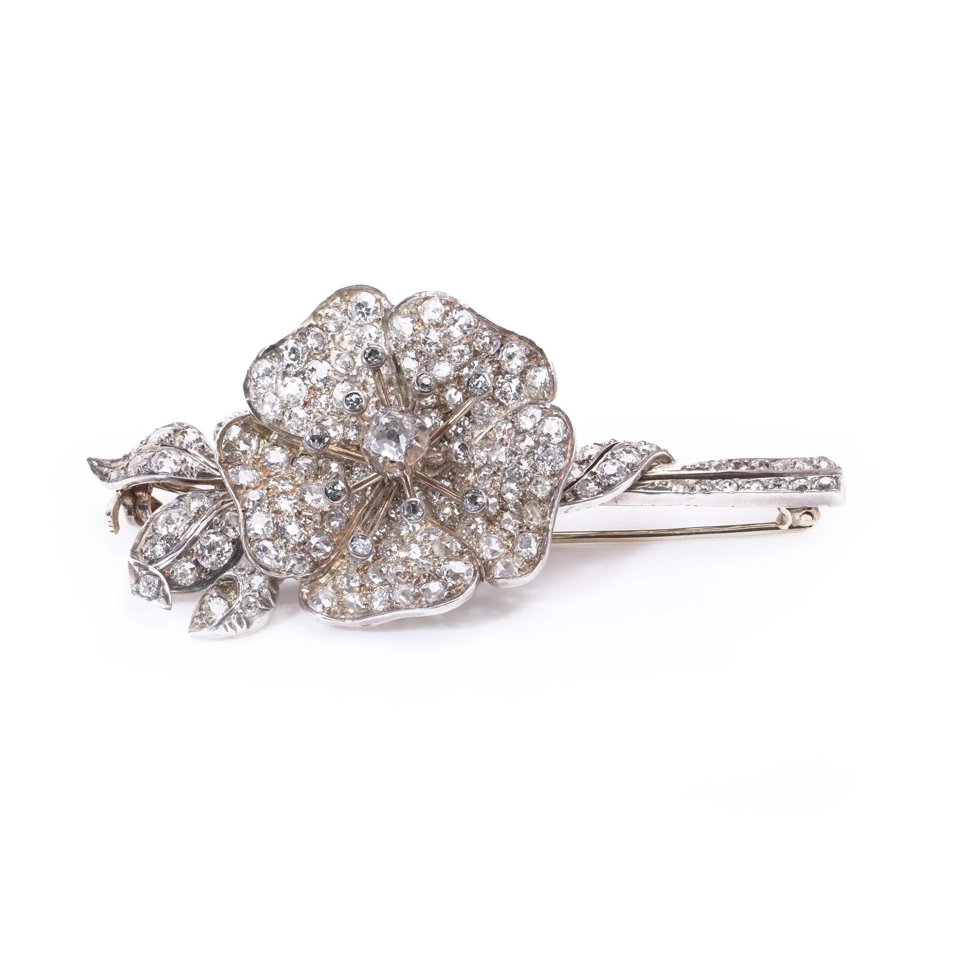 A decorative flower brooch set with diamonds, in silver and gold, on a white background