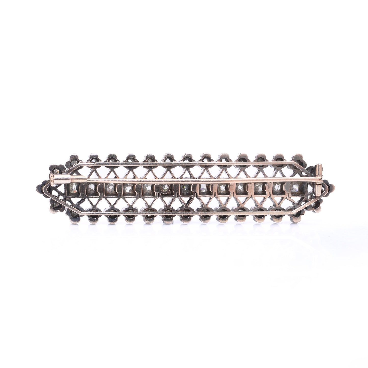 An openwork diamond set bar brooch in gold and silver, on a white background