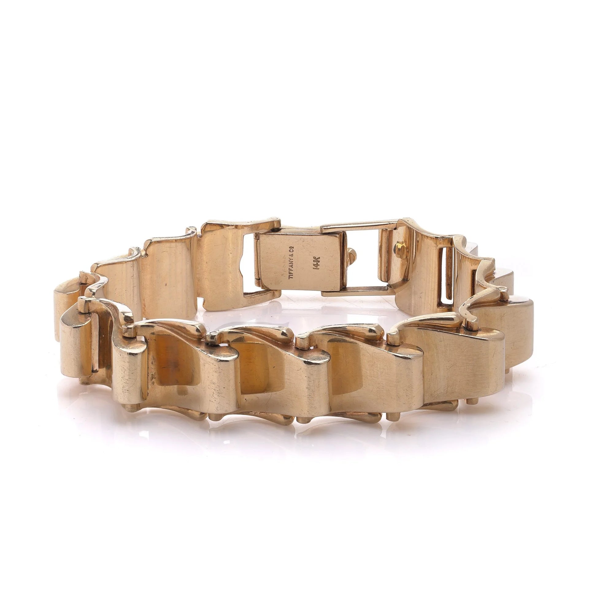 A yellow gold link bracelet with clasp, on a white background