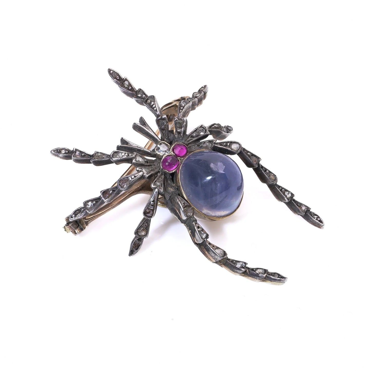 A spider brooch with a sapphire and ruby body and diamond legs, in silver and gold, on a white background
