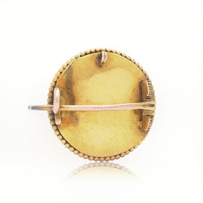 A yellow gold brooch back, on a white background