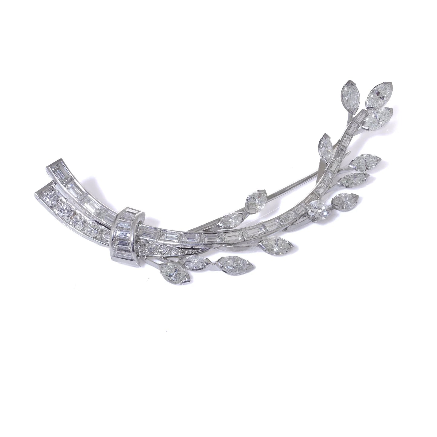 A leaf design brooch set with baguette, marquise and brilliant cut diamonds in white metal, on a white background