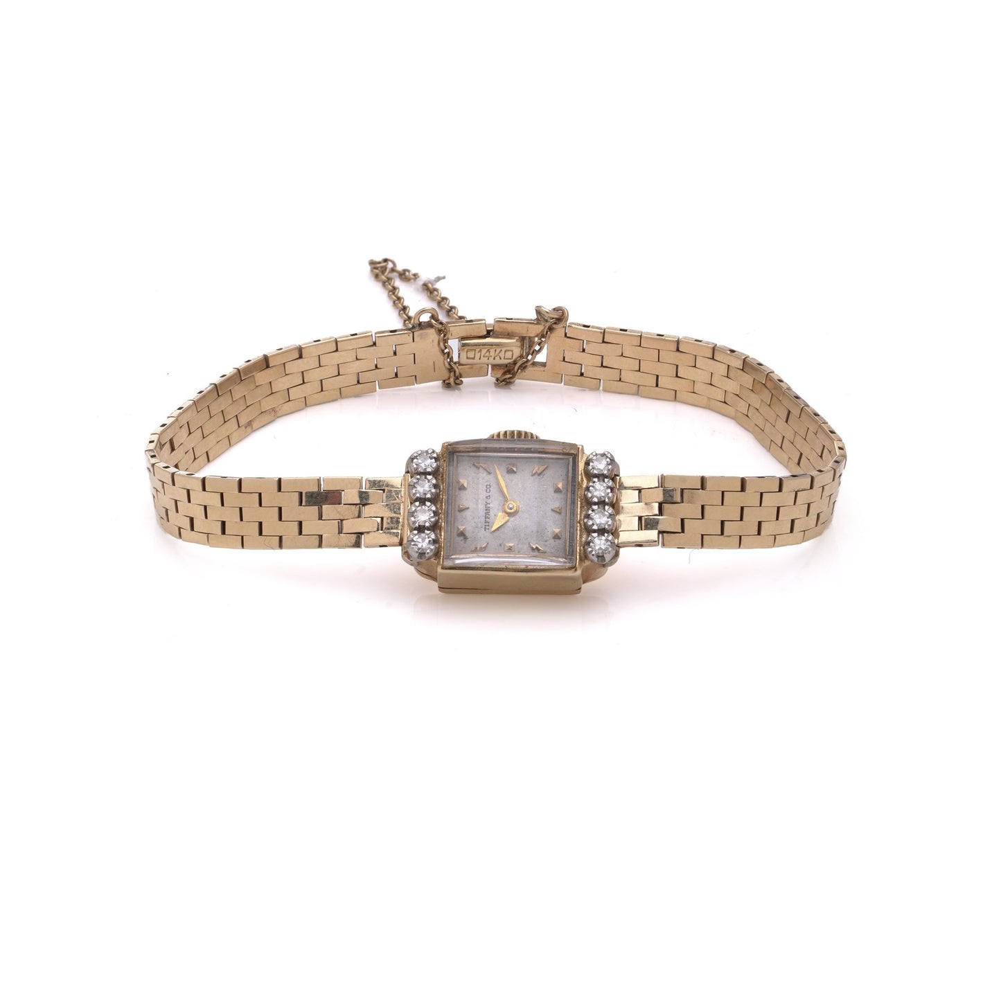 A yellow gold Tiffany & Co. diamond set wristwatch with a brick link bracelet, on a white background