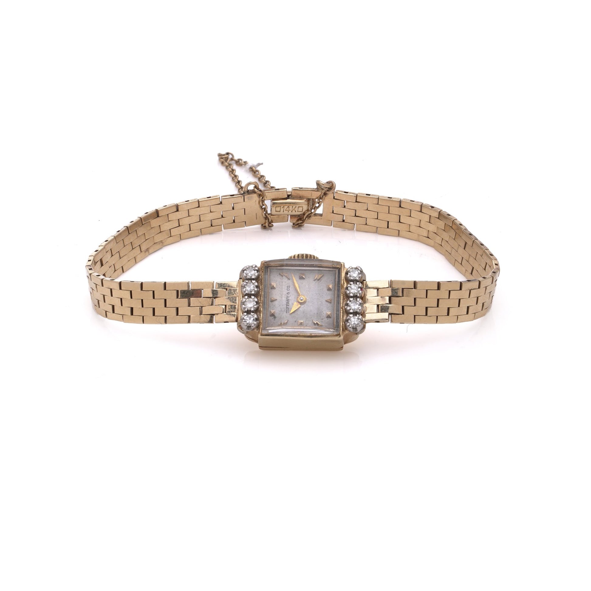 A yellow gold Tiffany & Co. diamond set wristwatch with a brick link bracelet, on a white background