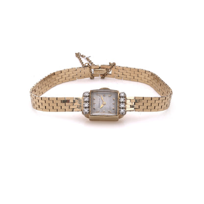 A yellow gold Tiffany & Co. diamond set wristwatch with a brick link bracelet, on a white background