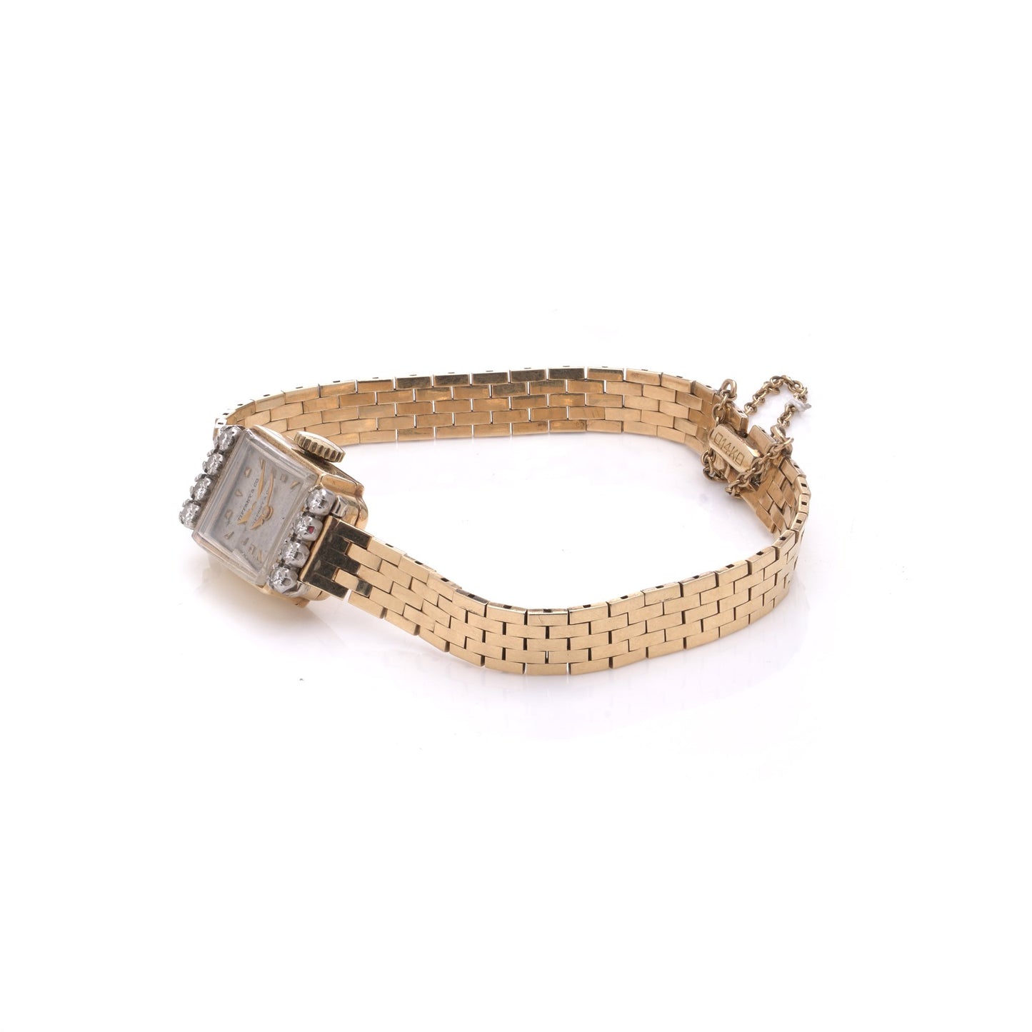 A yellow gold Tiffany & Co. diamond set wristwatch with a brick link bracelet, on a white background
