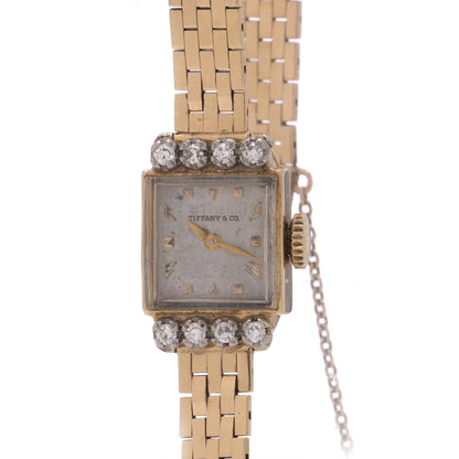 A yellow gold Tiffany & Co. diamond set wristwatch with a brick link bracelet, on a white background