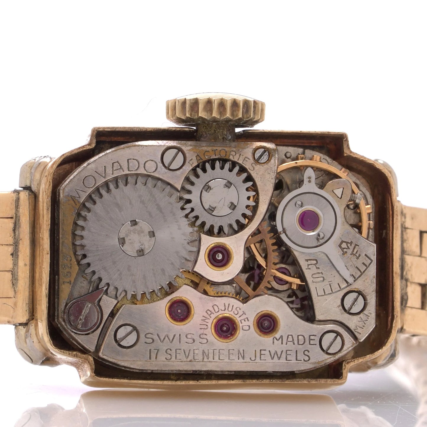 Close-up of a vintage watch mechanism with 'Movado' branding on a white background