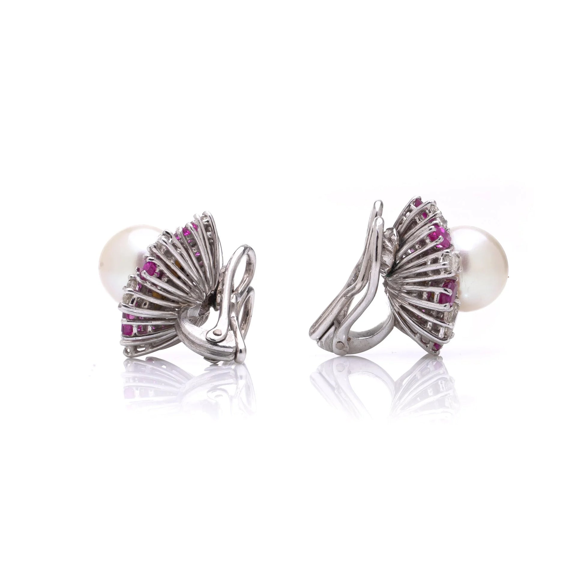 A pair of pearl, pink sapphire and diamond cluster earrings in white gold, on a white background