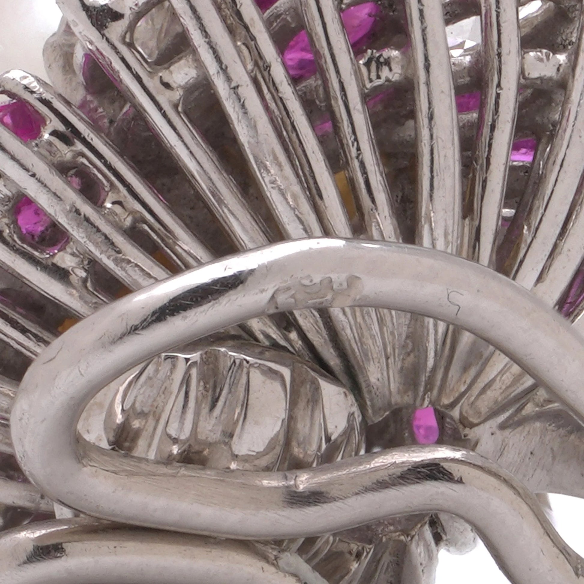 Close-up of a stamp on the back of a white gold earring fitting