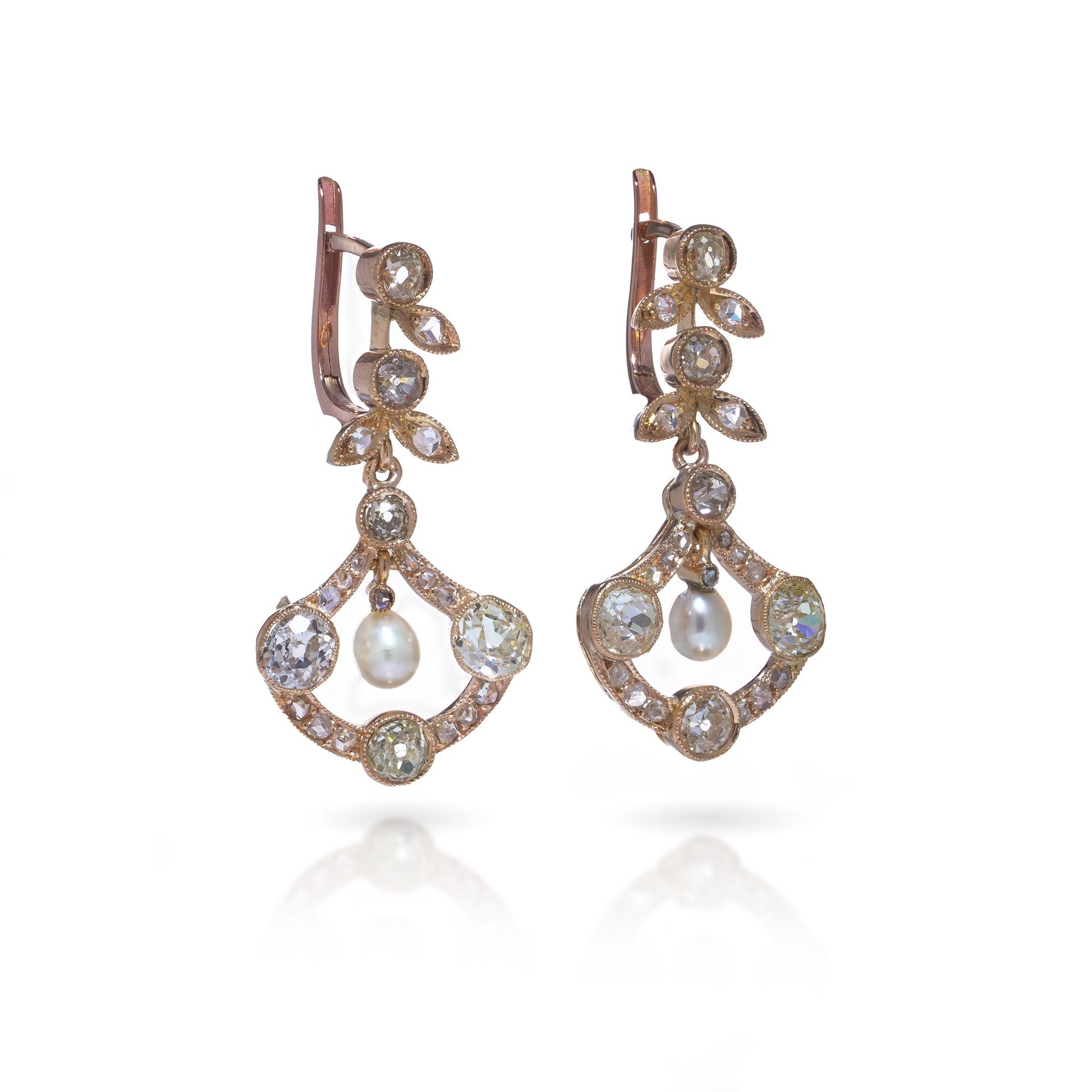 A pair of pearl and old cut diamond drop earrings with leaf motifs in yellow gold, on a white background
