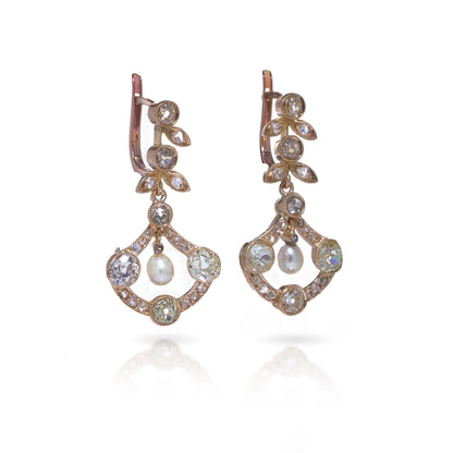 A pair of pearl and old cut diamond drop earrings with leaf motifs in yellow gold, on a white background