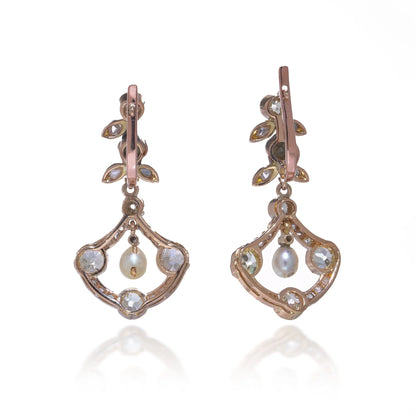 A pair of pearl and old cut diamond drop earrings with leaf motifs in yellow gold, on a white background