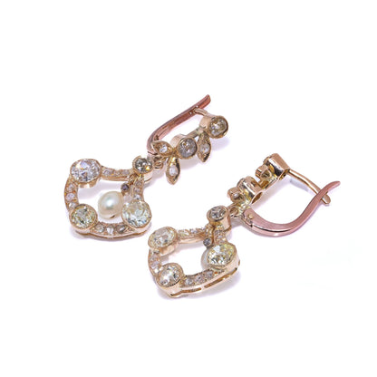 A pair of pearl and old cut diamond drop earrings with leaf motifs in yellow gold, on a white background