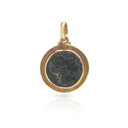 A yellow gold pendant featuring an oxidised ancient Roman coin, on a white background