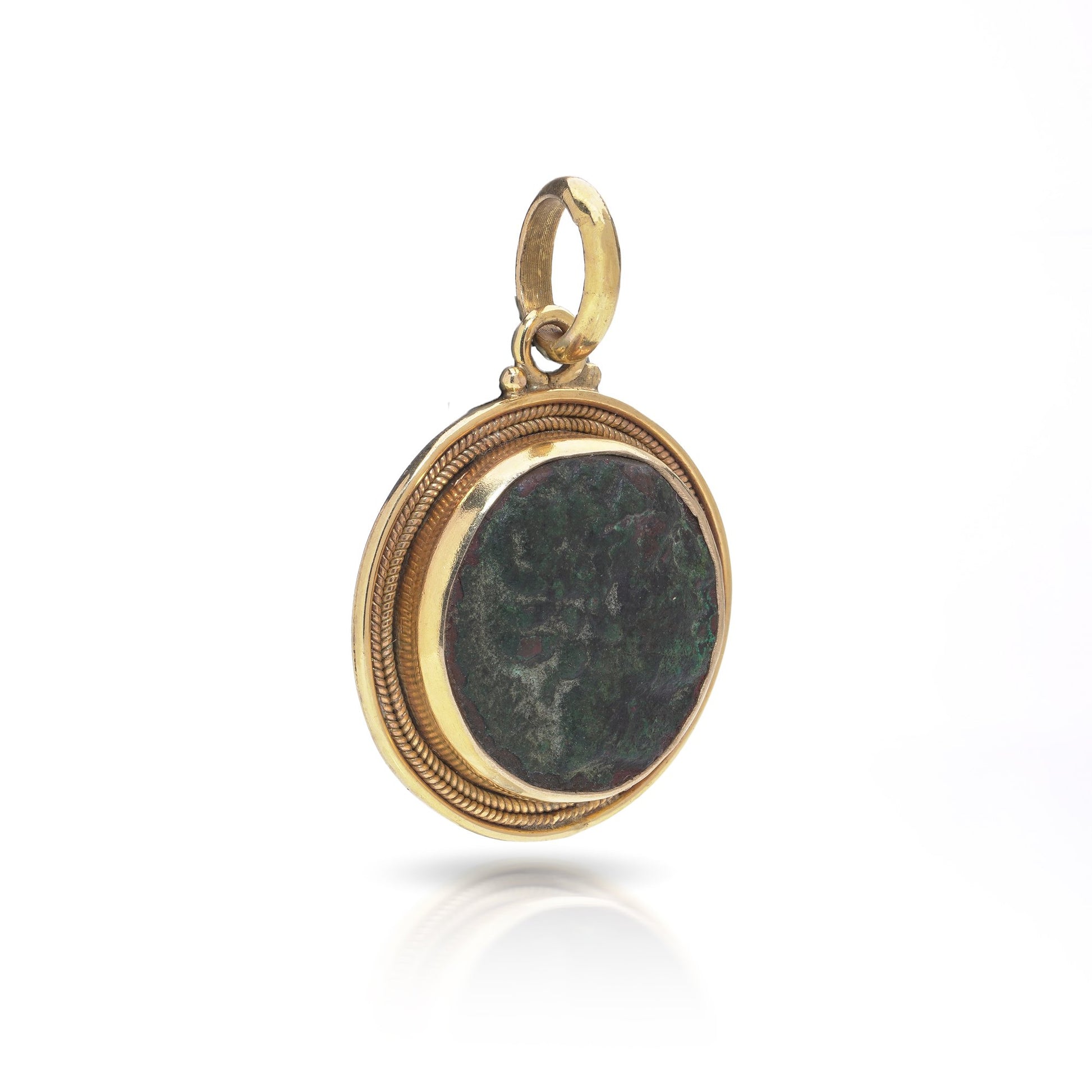 A yellow gold pendant featuring an oxidised ancient Roman coin, on a white background
