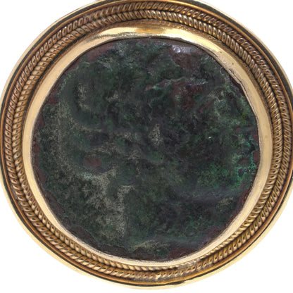 A yellow gold pendant featuring an oxidised ancient Roman coin, on a white background