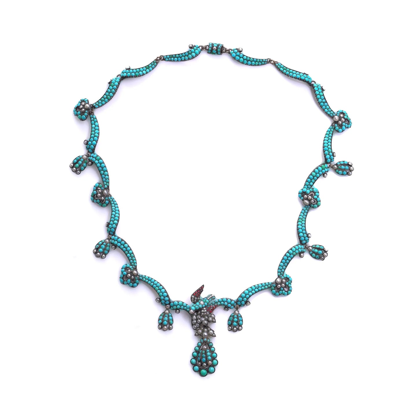 An antique turquoise bead and pearl fancy necklace with a bird motif, on a white background